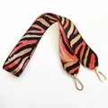 Detail of wide nylon bag strap featuring orange and black zebra pattern and gold hooks - Orange