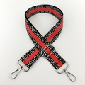 Detail eines verstellbaren Nylon-Schultergurts mit rot-schwarzem Punktmuster und Silberclips - Schwarz und Orange Mit Silberner Schnalle