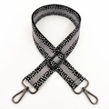 Detail eines verstellbaren gewebten Taschengurt mit geometrischem Muster und Karabinern - Grau und Schwarz Mit Gunmetal-Schnalle