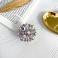 Detalle macro de un soporte de móvil de flor con brillantes diamantes de imitación - Iridiscente