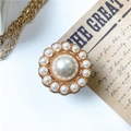 Dettaglio del supporto per telefono con perle di lusso e design vintage sole dorato - Oro
