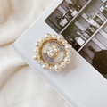 Close-up of pearl and rhinestone phone grip featuring a white camellia on a book - No.11 Small Camellia / White