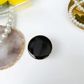 Dettaglio di un supporto per telefono tondo in smalto nero con elegante bordo dorato - Supporto galvanizzato tondo / Nero
