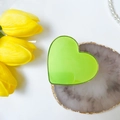 Dettaglio del supporto per telefono a cuore verde con bordo dorato su marmo e tulipani - Verde Fluorescente Gemma