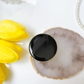 Dettaglio di un supporto per cellulare rotondo nero con eleganti bordi placcati oro - Nero