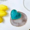 Dettaglio macro del supporto per telefono a cuore verde acqua con bordo dorato lucido - Blu Brillante Gemma