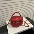 Red quilted chain crossbody bag with top handle and gold zipper for elegant winter fashion - Red