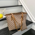 Sac cabas vintage avec motif monogramme et poignées en cuir sur un escalier chic - Kaki