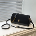 Zwarte leren crossbodytas met gouden ketting en metalen sluiting op een venster schaduw basis - Zwart