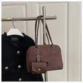 Detail einer braunen Wildleder-Bowlingtasche mit abnehmbarem Beutel und schmalen Riemen - Kaffeebraun