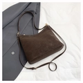 Gros plan sur un sac cabas vintage en daim marron avec deux sangles et détails dorés - café