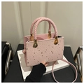Borsa a tracolla rosa con borchie a stella argentate e manico intrecciato su sfondo - 20*8.5*14.5cm / Rosa