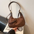 Brown suede half-moon shoulder bag with leather trim and gold hardware in stylish hand-held pose - Brown No Pendant
