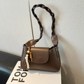Retro brown leather underarm bag with braided strap and decorative beads on white stand - With Pendant / Brown