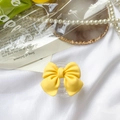 Detail of a matte yellow bow phone socket grip on a white silk and pearl background - Transparent Stand-Large Bow-Yellow