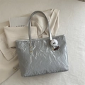 Silver metallic tote bag with wrinkled texture and plush monster charm on casual background - With Pendant / Silver