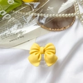 Yellow bow-shaped phone socket grip with matte texture on a white satin background - Transparent Stand-Large Bow-Yellow
