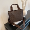 Brown tote bag with golden horsebit monogram and adjustable wide strap on book - Brown