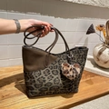 Large leopard print tote bag with plush heart charm shown in a cozy indoor setting - With Pendant / Green