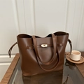 Bolso cubo vintage de cuero marrón con cierre metálico dorado y cordón de ajuste - café