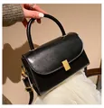 Classic black crossbody bag with gold hardware and top handle in a minimalist style - Black