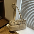 Chic beige suede underarm bag with belt detail and natural sunlight on a windowsill - Khaki