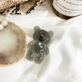 Translucent grey bear phone socket grip on white satin with decorative props - Transparent Gray
