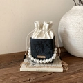 Mini drawstring bucket bag with pearl handle and gold chain strap in black and cream - Black