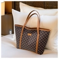 Detail der Textur der karierten Tragetasche und goldenes Fashion-Metall-Logo - Kaffeebraun