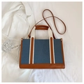 Detalle del bolso tote de lona azul con ribetes de cuero marrón y asas de cinta blanca - Estilo 1 (Azul/Marrón)