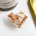 Macro d'un support de téléphone en cœur avec ours 3D et biscuit sur un bureau blanc - Support Coeur - Série Marron Transparent - N° 7