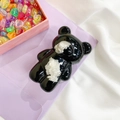 Macro detail of cute black resin bear phone socket with soft white plush texture details - Black Cloud Bear