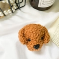 Dettaglio di un simpatico supporto per telefono in peluche marrone su sfondo bianco morbido - Cane - Caffè