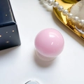 Pink spherical expanding phone grip stand with glossy resin finish on white desk - Pink