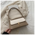 Detalle de bolso baguette beige vintage con texturas en contraste y hebilla dorada en chaqueta - Bloques de Color Caqui Oscuro y Blanco