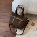 Brown wool-like tote bag with leather straps and metal buckle on soft white rug - Brown