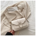 Close-up of cream-colored crossbody bag with unique geometric buckle and soft leather texture - White