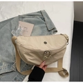 Top view of a beige nylon crescent crossbody bag with double zippers and fabric strap - Off White
