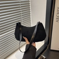 Minimalist black matte suede hobo bag shown in a stylish lifestyle setting with soft lighting - Black