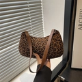 Fashionable leopard print underarm bag with brown leather strap in a modern room setting - Leopard Brown