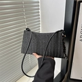 Detail of black woven shoulder bag with side knot accent and minimalist handle - With Pendant / Black