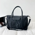Grande borsa da viaggio nera con tessuto a pieghe e manici in pelle in un ambiente di vita - Nero