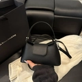 Chic black baguette handbag with top handle and crossbody strap in a minimalist style - Black