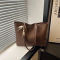 Minimalistische große braune Leder-Tote-Bag mit dekorativem Seidenschal auf Fensterbank - Braun