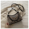Dettaglio borsa sottospalla leopardata appoggiata su blazer crema e un libro - Leopardo Cachi