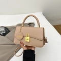 Borsa a tracolla beige minimalista con fibbia a lucchetto dorata su giacca grigia - Cachi