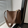 Minimalistische braune Leder-Eimertasche mit breitem Schultergurt und Goldakzenten - Braun