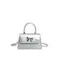 Silberne Pailletten-Handtasche mit Metallscheife und Umhängeriemen auf weißem Grund - Silber