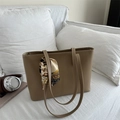 Sac fourre-tout en similicuir marron avec coutures contrastées et foulard sur un canapé - Kaki