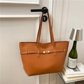 Bolso tote de cuero marrón con hebilla dorada colgado en una puerta blanca elegante - Marrón